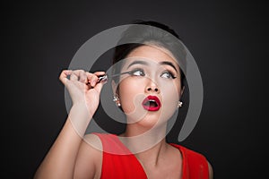 Make-up and cosmetics concept. Asian woman doing her makeup eyelashes black mascara.