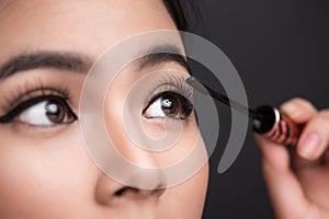 Make-up and cosmetics concept. Asian woman doing her makeup eyelashes black mascara.