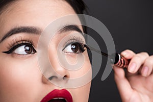Make-up and cosmetics concept. Asian woman doing her makeup eyelashes black mascara.