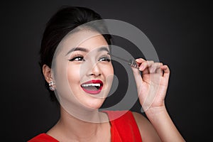 Make-up and cosmetics concept. Asian woman doing her makeup eyelashes black mascara.