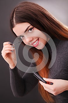 Make-up and cosmetics concept. Asian woman doing her makeup eyelashes dark mascara.