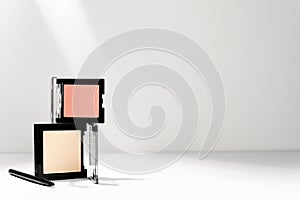 Make-up cosmetics kit. Face beige powder, pink blush and professional maquillage brush on white background. Decorative facial skin