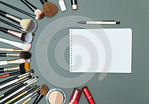 Make up the essentials. A set of professional makeup brushes and cosmetics on a gray background