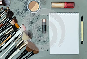 Make up the essentials. A set of professional makeup brushes and cosmetics on a gray background