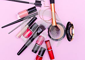 Make up the essentials. A set of professional makeup brushes and cosmetics on a pink background. Flatly.