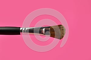 Make up powder brush on pink background