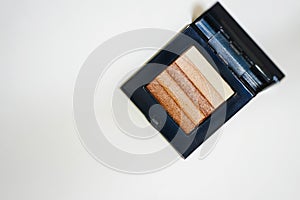 Make up powder in case ,earth tone on top view on isolated white