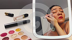 Daily make-up. Pretty Korean woman using eye liner. Asian girl making up eye lids. Morning routine. Bright make up for