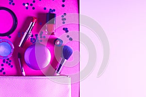 Make up products and brushes on purple neon