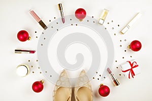 Make up products with Christmas decoration and golden womans shoes on white background with copy space flat lay