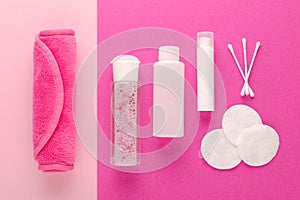 Make up remove products, micellar water, face cleaning cloth, cleansing milk and gel with cotton pads on pink background photo
