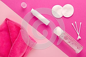 Make up remove products, micellar water, face cleaning cloth, cleansing milk and cotton pads on pink background