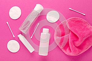 Make up remove products, micellar water, face cleaning cloth, cleansing milk and gel with cotton pads on pink background