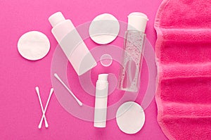 Make up remove products, micellar water, face cleaning cloth, cleansing milk and gel with cotton pads on pink background