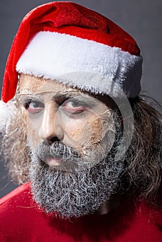 Make-up santa peeping out of the tree. halloween concept christmas zombie santa dead