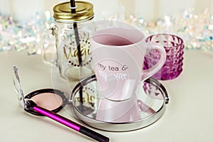 Make up set on wooden table with cup of tea top view