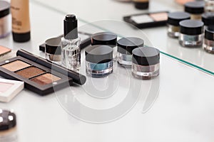 Make up tools on the white table. Eyeshadow, blush, concealer, p