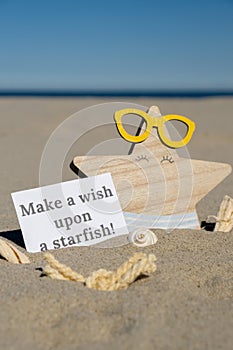 MAKE A WISH UPON A STARFISH text on paper greeting card on background of funny starfish in glasses summer vacation decor