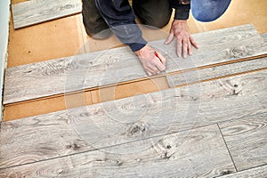 Make worker hands drawing line on laminate panel.