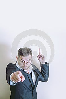 Make your choice. Portrait of handsome businessman wearing suit pointing at You and up. Free copy space for design and text