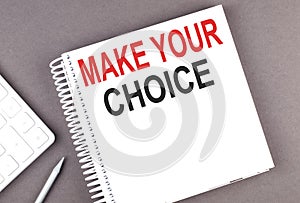 MAKE YOUR CHOICE text on the notebook with calculator and pen