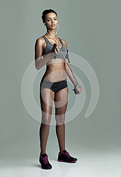 Make your workout work for you. Studio shot of a young woman working out with a resistance band against a gray
