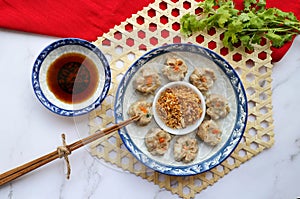 Siu mai - Chinese dumpling on the bamboo placemat.  Ka Mom Jib in Thai style dip wi