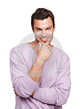 He makes the ladies swoon. A handsome man standing against a white background with his hand on his chin. photo