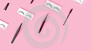 Makeup accessories. Fake eyelashes. Tools for eye lash extensions on pink background. Curler, tweezers, brush, mascara.