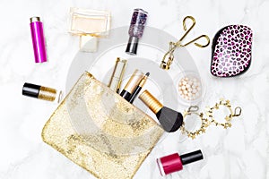 Makeup and accessories gold and pink for girls on the table. Fla
