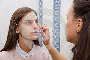 Makeup artist aligns tonal crem on the face of the model
