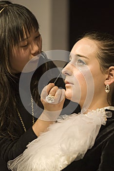 Makeup artist applies eye shadow