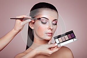 Makeup artist applies eye shadow