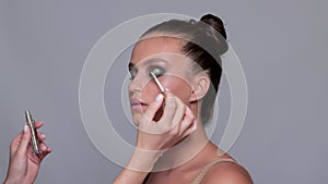 Makeup artist applies eye shadow.The concept of aesthetic cosmetology and makeup