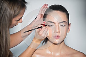 Makeup artist applies eye shadow. Hand of visagiste, painting cosmetics of young beauty model girl. Natural skin, clean