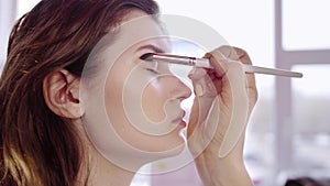 Makeup artist applies eyes shadow