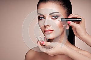 Makeup artist applies skintone photo