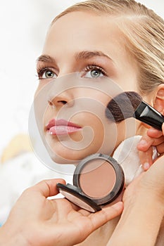 Makeup artist apply blush on cheeks