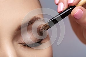 Makeup artist apply makeup brush for eyes. makeup for young girl. brown eye shadow. close up