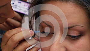 Makeup artist apply makeup on the eyes of young woman. Professional makeup artist applying makeup for bride. Weeding