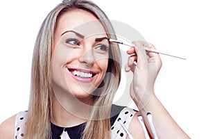 Makeup artist applying eye shadow on the face of the woman, isolated on white
