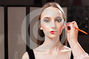 Makeup artist applying eye shadows on a model