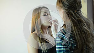 Makeup artist applying lips contour with special crayon