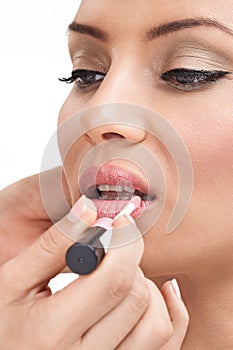 Makeup artist applying lips-gloss on model