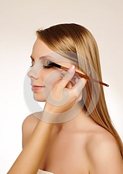 Makeup artist applying mascara photo