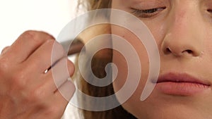 Makeup artist applying shimmer powder on beauty