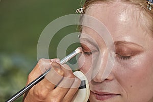 Putting makeup on a beautiful white and blonde model photo