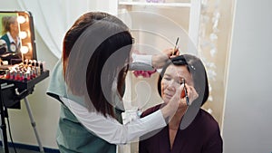 Makeup Artist Dying Eyebrows for Senior Woman