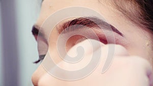 Makeup artist glueing false eyelashes to the eyes