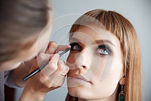 Makeup artist glues false eyelashes